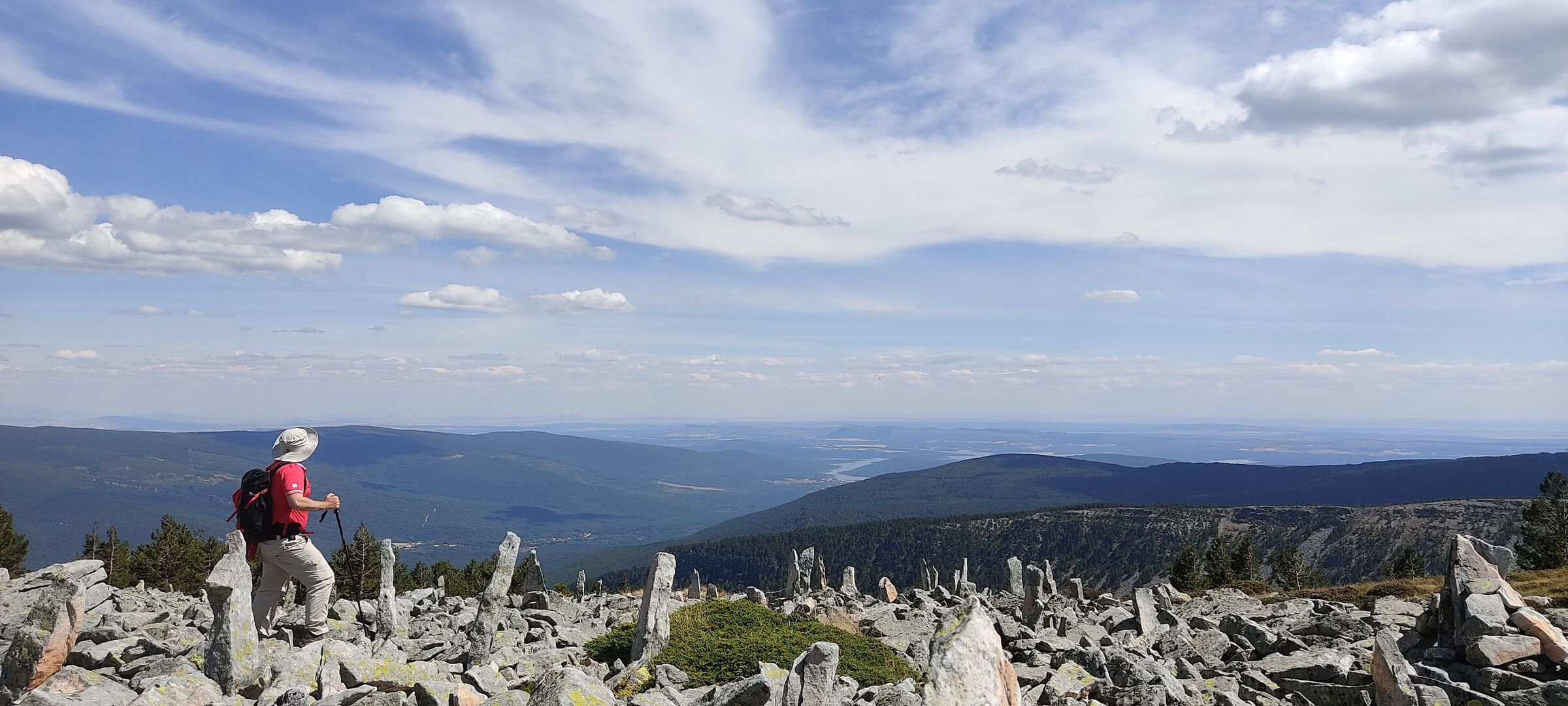 Javier hiking among standing stones above a wide valley